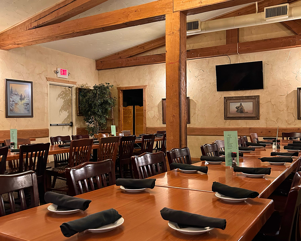 Cozy dining area with wooden beams and neatly set tables.