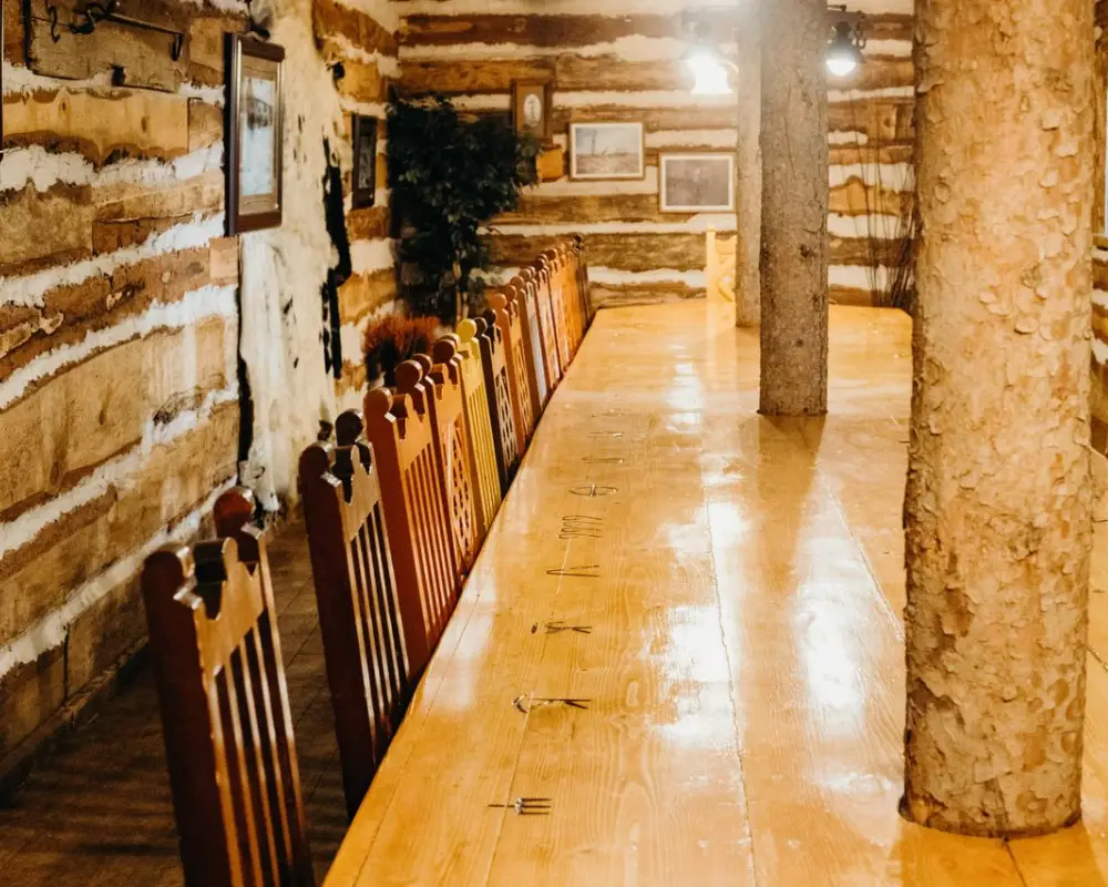 Long wooden table with chairs in a rustic cabin interior.